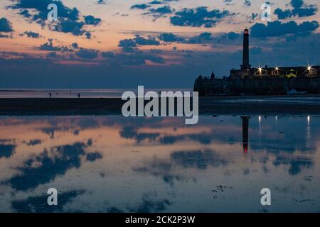 Wunderschöne Spiegelung des Sonnenuntergangs und des Leuchtturms bei Ebbe am Margate Harbour Arm - Margate, Thanet, Kent, England, Vereinigtes Königreich Stockfoto