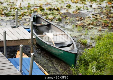 Ein Kanu dockte an einem Pier am Long Lake in Littleton, Massachusetts, USA. Stockfoto