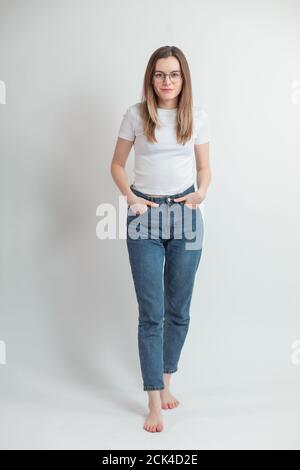 Lächelnd junge selbstbewusste Frau in Straßenkleidung Stockfoto