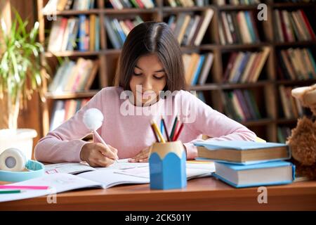 Niedlich smart hispanischen indisch Schule Mädchen studieren am Tisch zu Hause. Stockfoto