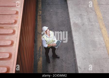 Container Shipping Logistics Engineering der Import / Export Transportindustrie, Transport Engineer ist Controlling Management Container Box auf LAPT Stockfoto