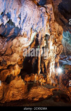 Erkunden mystische Kalksteinhöhle mit Fackel, magische Form und Textur von Stalaktiten und Stalagmiten in der großen Höhle. Nam Nao, Thailand. Stockfoto