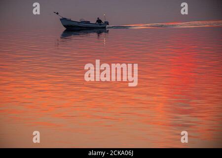 Wismar, Deutschland. September 2020. Kurz vor Sonnenaufgang fährt ein Fischer sein Motorboot durch die Wismarer Bucht in Richtung offenes Meer. Quelle: Jens Büttner/dpa-Zentralbild/dpa/Alamy Live News Stockfoto