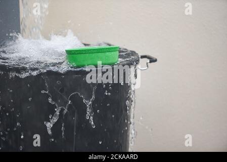 Eimer mit Wasser spritzt Regen Wasser Ernte im Eimer Von Wasser nach Regen Stockfoto