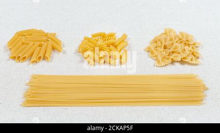 Verschiedene Pasta auf einem Stoff Hintergrund. Verschiedene rohe Pasta. Glutenfreie Speisen. Stockfoto