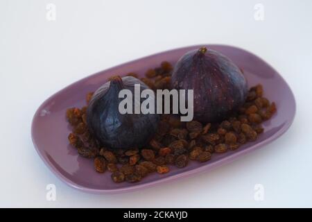 Obst. Feige und Rosinen auf einer Platte. Weißer Hintergrund. Stockfoto