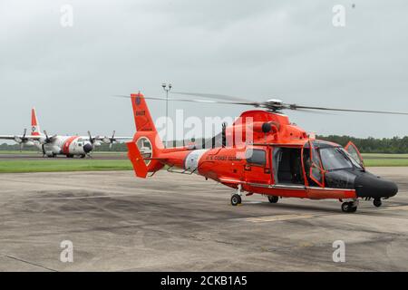 Ein Flugzeug der Küstenwache Clearwater HC-130J und ein Hubschrauber der Küstenwache New Orleans MH-64 Dolphin sitzen auf dem Asphalt der Küstenwache New Orleans, 15. September 2020. Das Flugzeug war gerade angekommen, um zusätzliche Teile und Vorräte sowie ein Fahrzeug zur Unterstützung der Reaktion auf den Hurrikan Sally abzusetzen. (Foto der US-Küstenwache von Petty Officer, 3. Klasse, John Michelli) Stockfoto