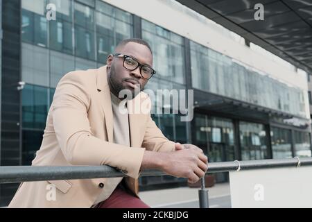 Porträt eines afrikanischen jungen Mannes in Jacke Blick auf die Kamera Während Sie in der Stadt stehen Stockfoto