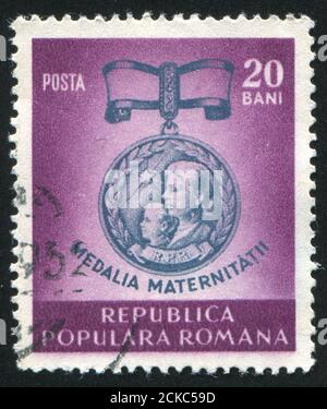 RUMÄNIEN - UM 1952: Briefmarke gedruckt von Rumänien, zeigt Medaille für Mutterschaft, um 1952 Stockfoto