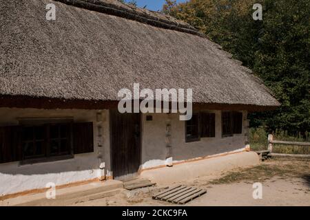 Ein weißes slawisches Haus mit Strohdach Stockfoto