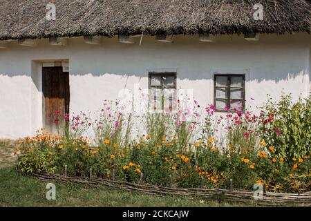 Ein weißes slawisches Haus mit Strohdach Stockfoto