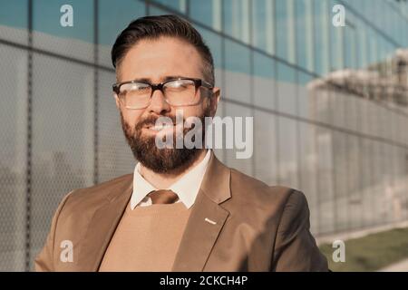 Porträt eines reifen bärtigen Geschäftsmannes in Brillen lächelnd an der Kamera In der Stadt Stockfoto