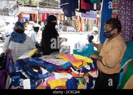 Dehradun, Uttarakhand/Indien - September 10 2020:Frauen kaufen Tücher vom Verkäufer, tragen Gesichtsmaske. Stockfoto