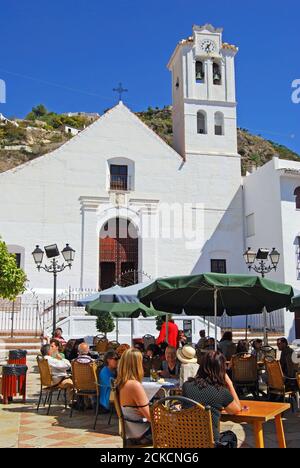 San Antonio Kirche mit einem Straßencafé im Vordergrund, Frigiliana, Spanien. Stockfoto