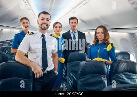 Waist up Porträt des Flugpersonals Team trägt Uniformen lächelnd Und stolz auf die Arbeit mit Passagieren in der Luftfahrt Stockfoto