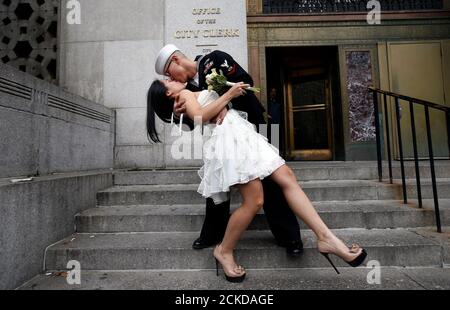 US Navy Petty Officer 3rd Class EO3 John Chen, 23, aus Lakehurst, New Jersey, küsst seine neue Braut Victoria Chan, 25, aus Manhattan, als sie für Fotografen posieren, nachdem sie in einer standesamtlichen Zeremonie im Büro des Stadtarbeiters von New York City am 12. Dezember 2012 geheiratet wurden. Hunderte von Paaren packten das Büro in Lower Manhattan, um am 12./12/12. Verheiratet zu werden, da dies das letzte solche dreifache Datum für fast ein Jahrhundert bis zum 1. Januar 2101 sein wird. REUTERS/Mike Segar (VEREINIGTE STAATEN - Tags: GESELLSCHAFTSPORTRÄT)