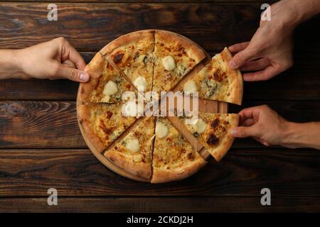 Hände halten Scheiben von leckeren Käse Pizza, Draufsicht Stockfoto