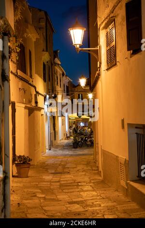 Restaurant in alten beleuchteten engen Straße in Mahon bei Nacht - Menorca, Spanien Stockfoto