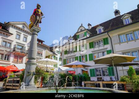 Brunnen-Mandl auf dem zentralen platz in Schwyz. Die mittelalterliche Stadt Schwyz ist die Hauptstadt des Kantons Schwyz in der Schweiz. Die Federa Stockfoto