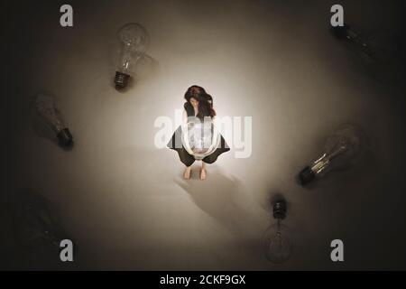 Kreative Idee Konzept, surreale Frau hält die eine Glühbirne unter vielen Stockfoto
