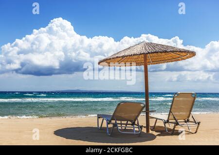 Griechischer Strand mit Sonnenliegen und Strohschirm auf der Insel Zakynthos. Griechenland Stockfoto