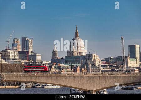 Ein Bus überquert die Waterloo Bridge mit der St Pauls Cathedral und den Hochhäusern der City of London in der Ferne, London, Großbritannien Stockfoto