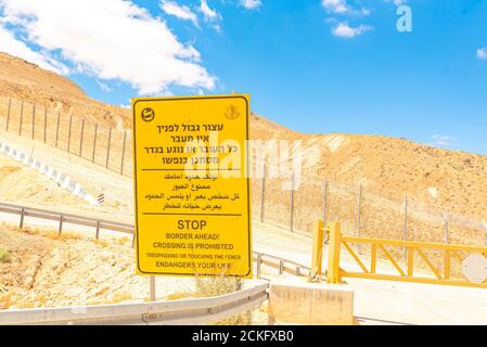 Route 10 entlang der ägyptisch-israelischen Grenze. Blick in Ägypten aus Israel Gelbe Grenze voraus Warnschild in Hebräisch Arabisch und Englisch Stockfoto