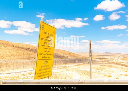 Route 10 entlang der ägyptisch-israelischen Grenze. Blick in Ägypten aus Israel Gelbe Grenze voraus Warnschild in Hebräisch Arabisch und Englisch Stockfoto