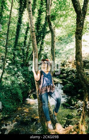Junge Frau am Baum im Wald Stockfoto