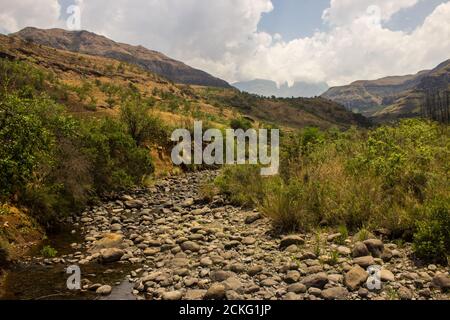 Der Fluss Injisuthi, mit dem Gipfel der Mönchskuppe im fernen Hintergrund, in den Central Drakensberg Mountains in Südafrika Stockfoto