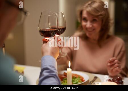 Nahaufnahme eines Paares beim Toasten mit Gläsern Rotwein Die Tabelle Stockfoto
