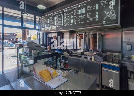 Ein Mann, der in einem modernen, sauberen Döner-Kebab-Laden in der King Street in der Innenstadt von Newtown in Sydney, Australien, arbeitet Stockfoto