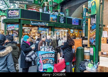 Kunden kaufen Getränke an einem Stand im Londoner Borough Market , einer der größten und ältesten Lebensmittelmärkte in London Stockfoto