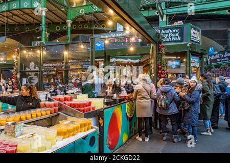 Leute, die frischen Fruchtsaft an einem frischen Fruchtsaftstand in Borough Market, Southwark, London kaufen Stockfoto