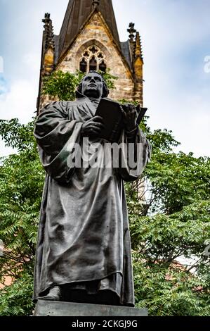 Das Erfurter Lutherdenkmal befindet sich auf der Nordseite der Angers in Erfurt. Die Bronzestatue zeigt den Reformator mit der offenen Bibel in der Hand. Stockfoto