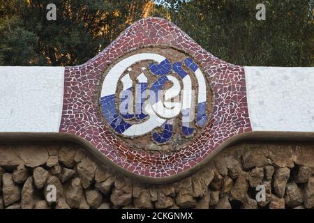 Trencadís Mosaik-Inschrift auf dem Zaun des Park Güell von katalanischen modernistischen Architekten Antoni Gaudí entworfen und zwischen 1900 und 1914 in Barcelona, Katalonien, Spanien gebaut. Stockfoto