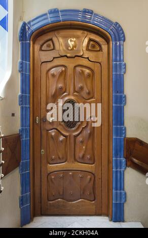 Holztür einer der Wohnungen in der Casa Batlló in Barcelona, Katalonien, Spanien. Das Herrenhaus, das vom katalanischen modernistischen Architekten Antoni Gaudí für die Familie Batlló als Einnahmehaus sowie als private Familienresidenz entworfen wurde, wurde zwischen 1904 und 1906 erbaut. Stockfoto