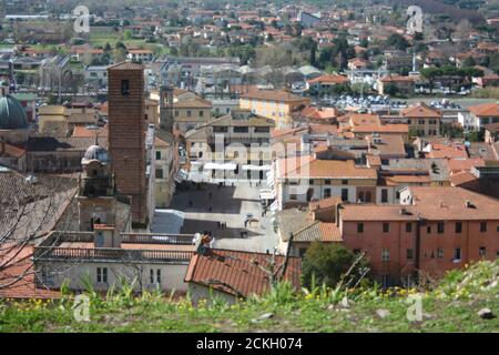 Die roten Dächer der bewohnten Häuser, die Kirche und der Glockenturm der kathedrale von pietrasanta vom Grün eines Hügels an der Spitze aus gesehen Stockfoto