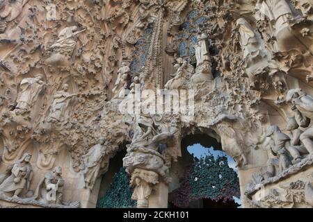 Weihnachtskrippe auf der Krippenfassade der Sagrada Família (Basílica de la Sagrada Família), die vom katalanischen modernistischen Architekten Antoni Gaudí in Barcelona, Katalonien, Spanien entworfen wurde. Engel und Kinder spielen und singen über der Krippe. Die Weihnachtsfassade wurde von Antoni Gaudí selbst entworfen und zwischen 1894 und 1930 gebaut. Die Statuen wurden vom katalanischen Bildhauer Llorenç Matamala i Piñol geschnitzt. Stockfoto