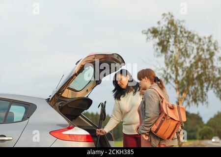 Zwei Freunde packen Sachen in das Auto, das sie gehen Um mit dem Auto auf ihren Urlaub zu reisen Stockfoto