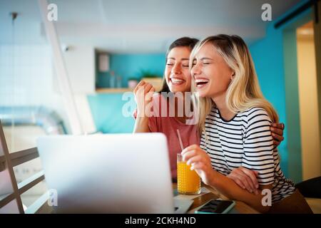 Junge weibliche Freunde im Internet surfen und sich gemeinsam amüsiert