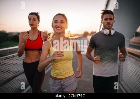 Fit fröhlich Freunde joggen und laufen im Freien in der Stadt Stockfoto