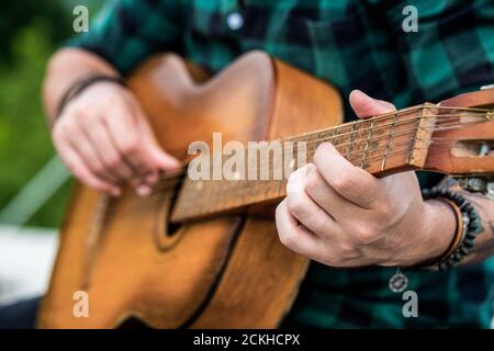 Akustische Gitarren spielen. Musikkonzept. Gitarren akustisch. Live-Musik. Musikfestival. Männlicher Musiker spielt Gitarre, Musikinstrument. Die Hände des Mannes Stockfoto