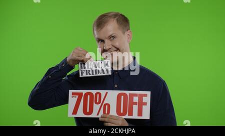 Schockiert erstaunt Emotionen des Store-Kunden. Mann zeigt Black Friday und bis zu 70 Prozent aus Inschriften Zeichen. Gute Urlaubsrabatte, niedrige Preise zum Einkaufen. Chroma-Taste Hintergrund Stockfoto
