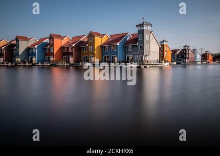 Bunte Häuser entlang eines Wasserkanals an einem sonnigen Tag in Groningen, Niederlande Stockfoto