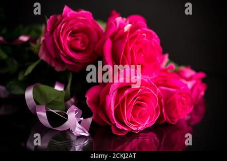 Schönes Bouquet von roten Rosen auf schwarzem Hintergrund Stockfoto