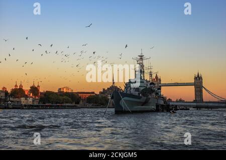 Sonnenuntergang über London - wunderschöne Aussicht auf die HMS Belfast bei Sonnenuntergang, vor der Tower Bridge und dem Tower of London Stockfoto