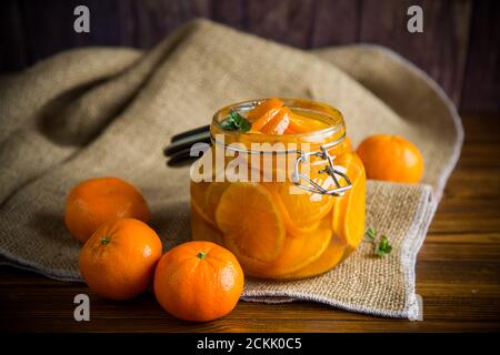 Mandarinenmarmelade in einem Glasgefäß auf einem Holztisch Stockfoto