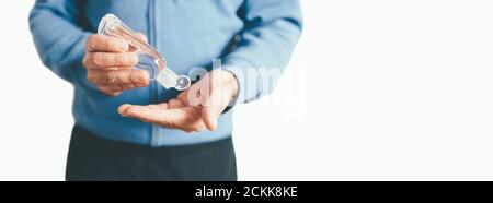 Mann, der Handdesinfektionsmittel auf seine Hände anwendet, um eine Ausbreitung zu verhindern Covid-19 Coronavirus Stockfoto