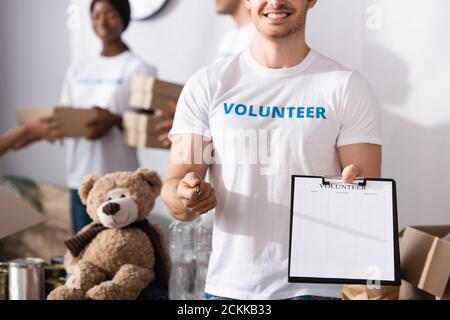 Selektiver Fokus der Freiwilligen hält Zwischenablage und Stift in der Nächstenliebe Zentrieren Stockfoto